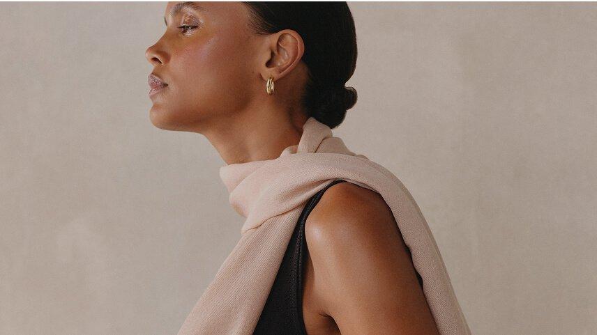 a woman is holding a pillow over her head and shoulders