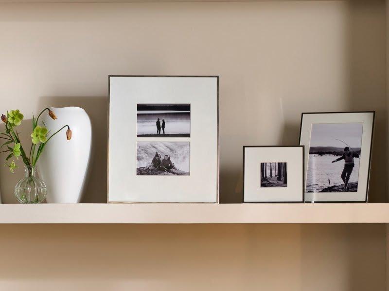 a group of framed pictures on a shelf in a room