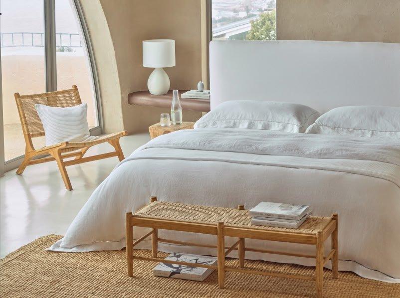 a bedroom with a white bed and a chair in it
