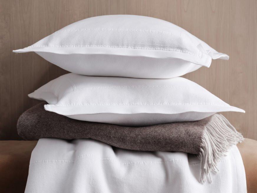 a stack of pillows and blankets on a wooden table