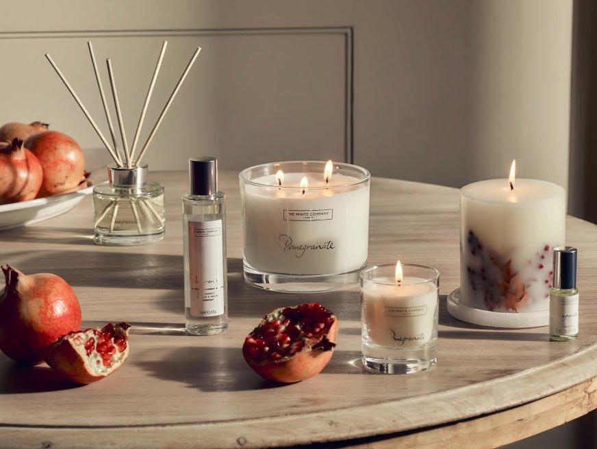 a table with candles and pomegranates on it and a bowl of fruit
