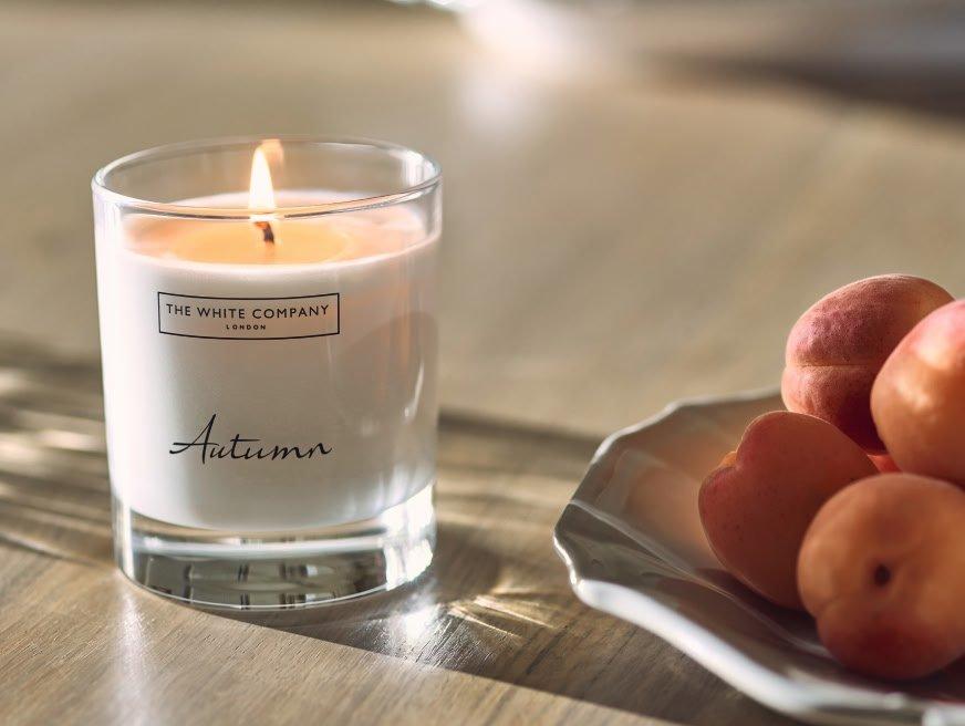 a candle and a plate of peaches on a table