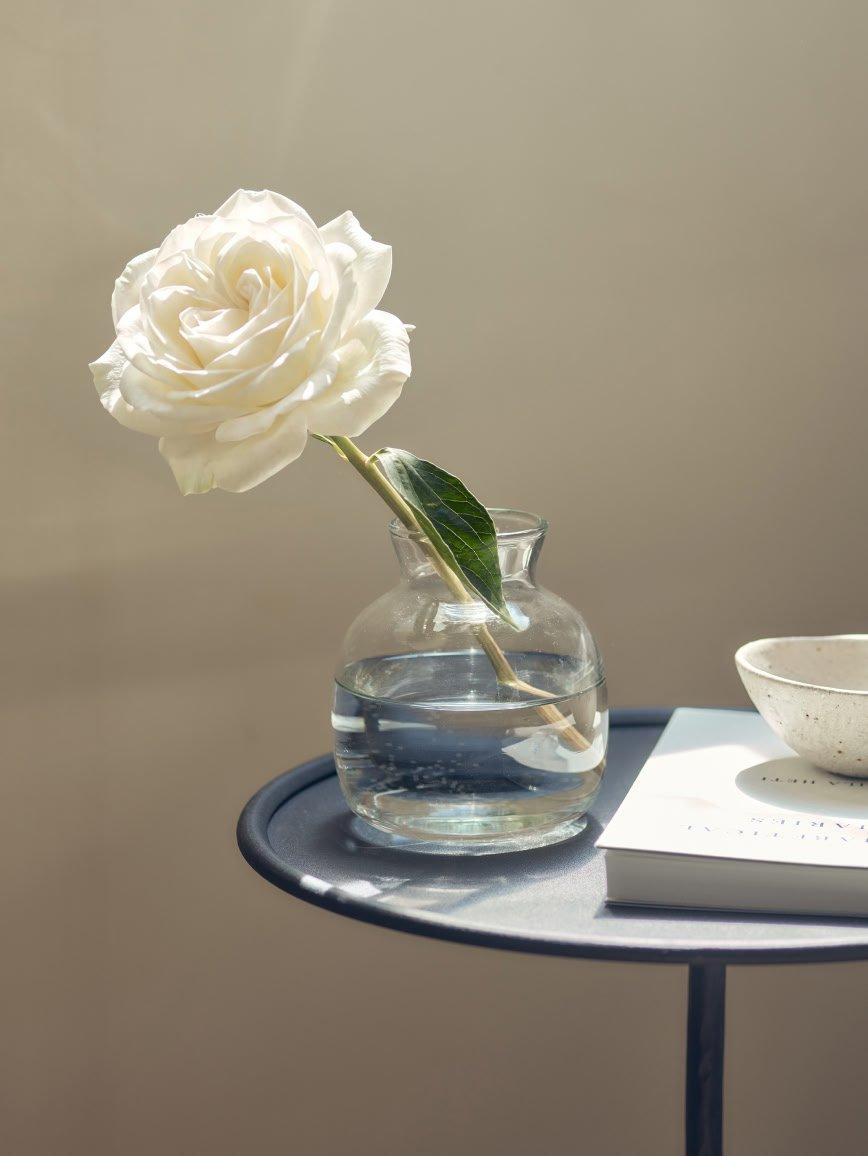 a clear vase with white flowers in it on a table