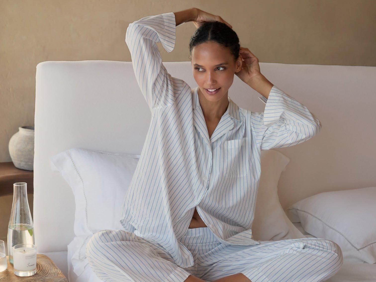 a woman in a white shirt and pants poses for a picture