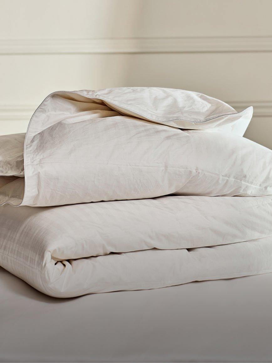 a stack of white sheets with yellow pillows on top of them