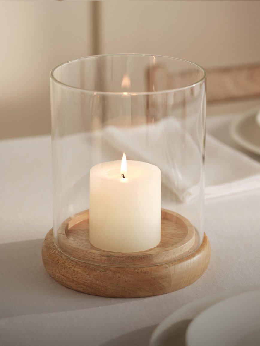 a candle in a wicker candle holder with a white candle