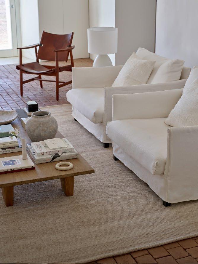 a living room with white furniture and a coffee table