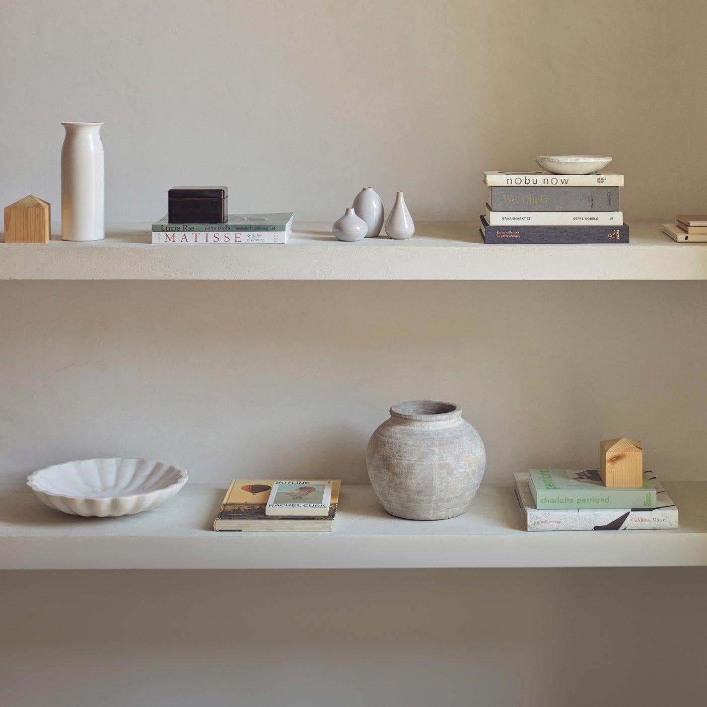 a shelf with a vase, a bowl and a book on it