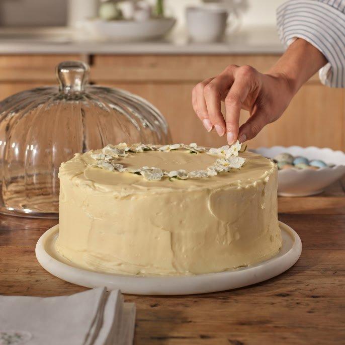 a person is cutting a cake with a knife on a table